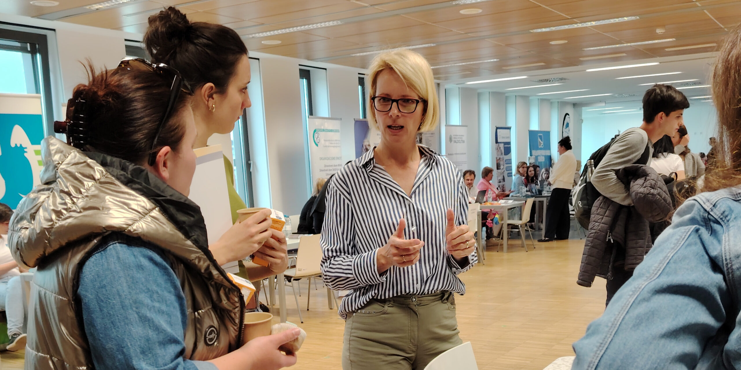 Besucherinnen im Gespräch mit einer Ausstellerin auf der Jobmesse der Medizinischen Fakultät der UM.