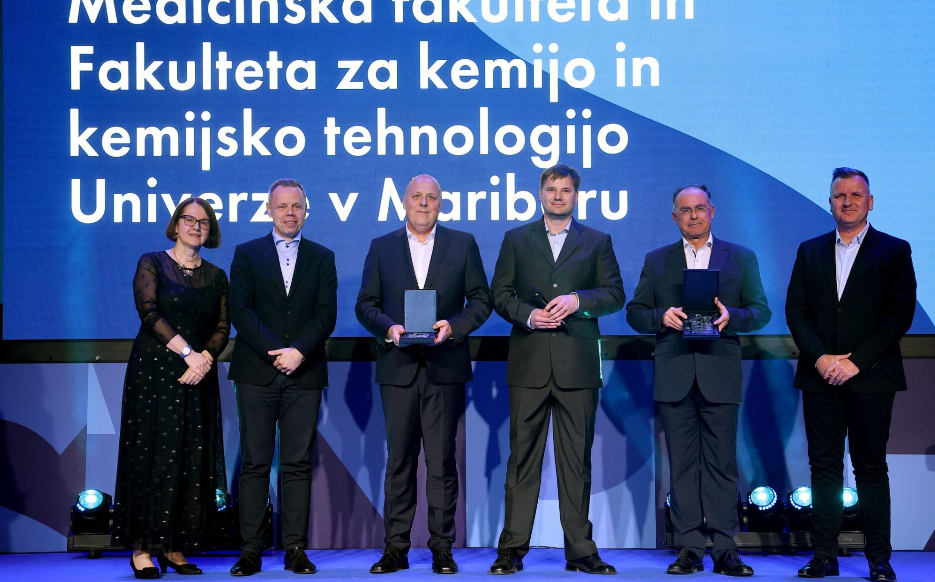 Skupinska fotografija prejemnikov priznanj Lekova zvezda 2025 pred projekcijskim zaslonom.