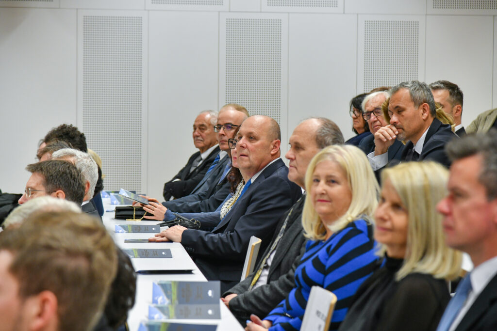 Gostje poslušajo program ob mizah v predavalnici. Praznovanje 20. obletnice Medicinske fakultete UM.