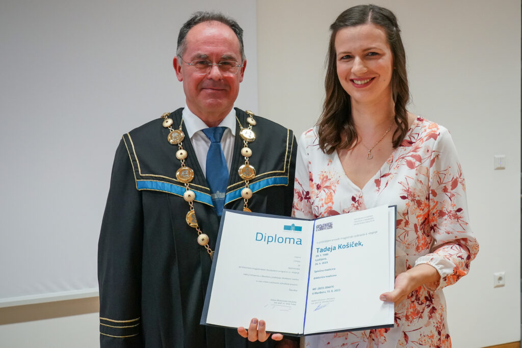 Diplomantka v cvetlični obleki z dekanom in diplomo. Podelitev diplom Medicinske fakultete UM, 15. junija 2023.