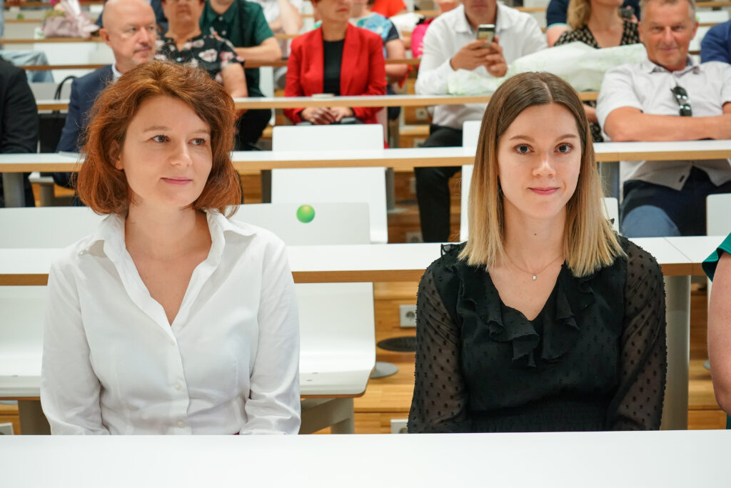 Dve diplomantki v prvi vrsti poslušata program. Podelitev diplom Medicinske fakultete UM, 15. junija 2023.
