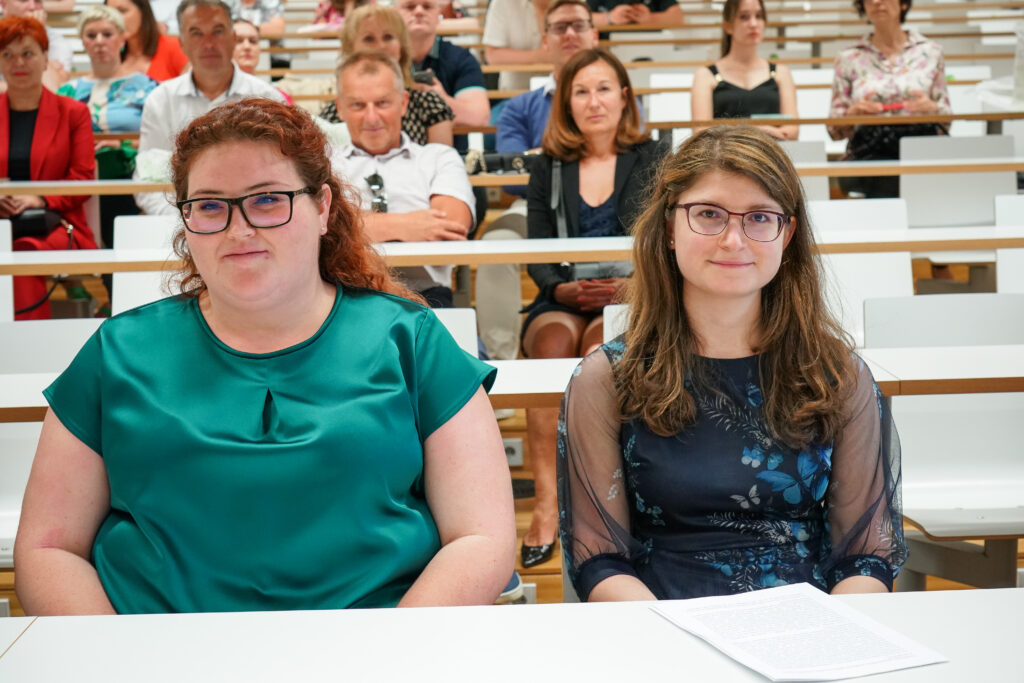 Diplomantki v zeleni in modri obleki spremljata slovesnost. Podelitev diplom Medicinske fakultete UM, 15. junija 2023.
