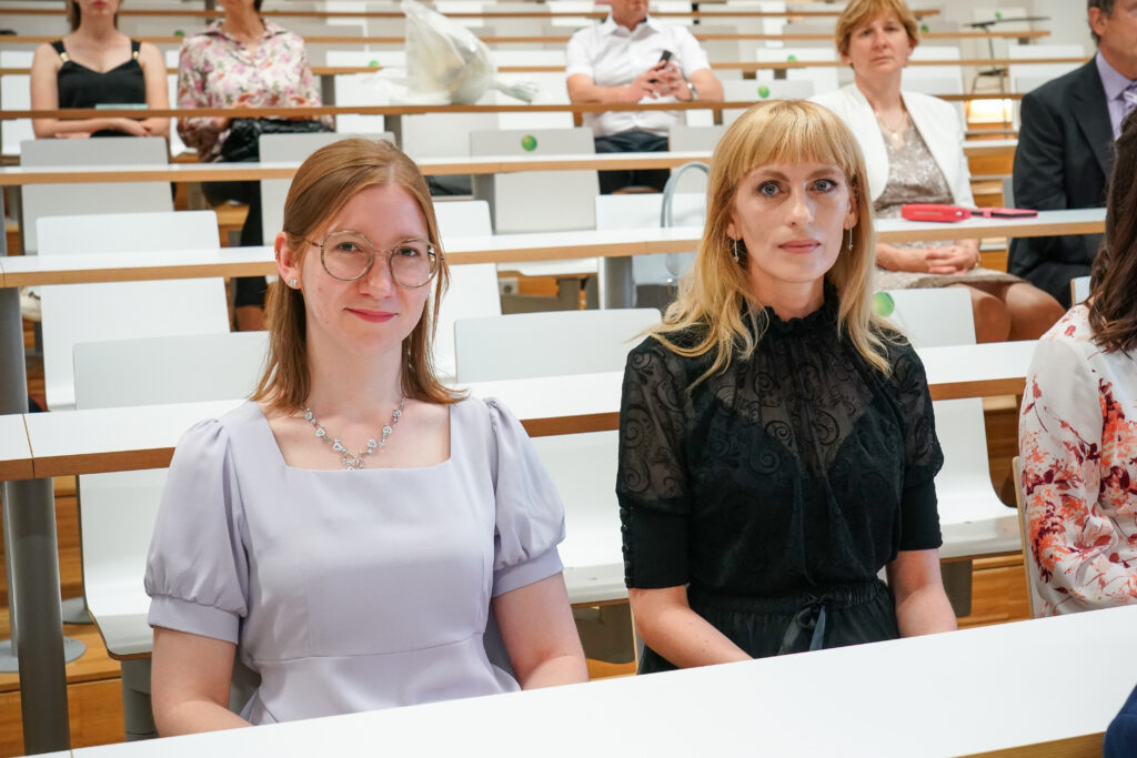 Diplomantki v sivi in črni obleki sedita v predavalnici. Podelitev diplom Medicinske fakultete UM, 15. junija 2023.
