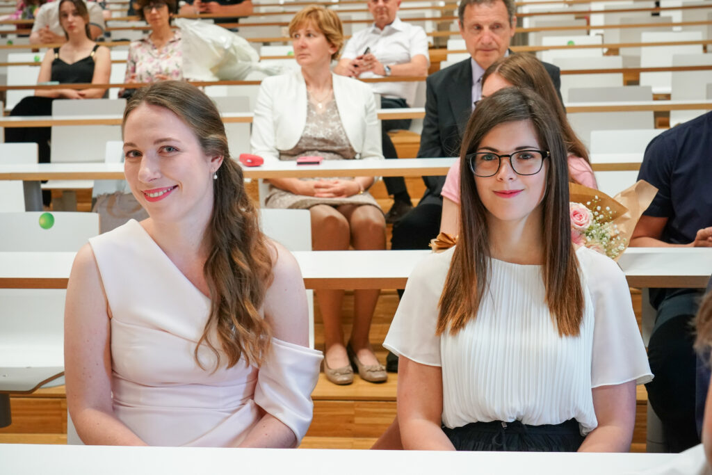 Dve diplomantki sedita skupaj v prvi vrsti. Podelitev diplom Medicinske fakultete UM, 15. junija 2023.