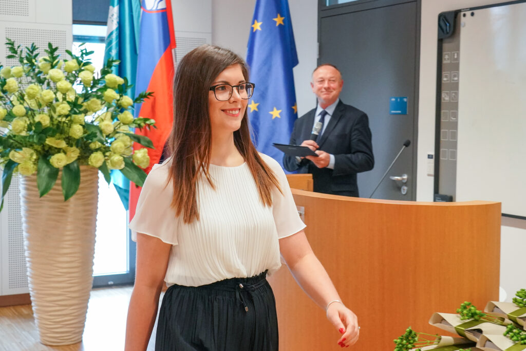 Diplomantka odhaja mimo govorniškega pulta. Podelitev diplom Medicinske fakultete UM, 15. junija 2023.