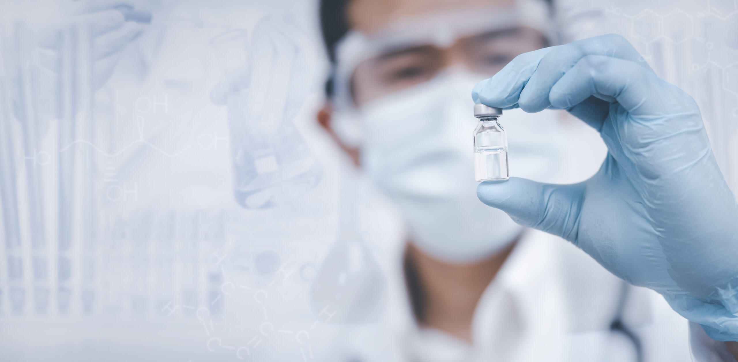 Raziskovalec drži vialo v laboratoriju